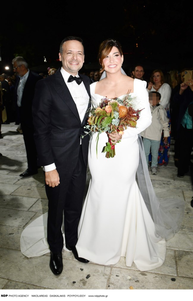 Η elegant εμφάνιση της κουμπάρας του Χάρη Δούκα: Το απίθανο σατέν φόρεμα με τα ασύμμετρα βολάν στις αποχρώσεις του στολισμού