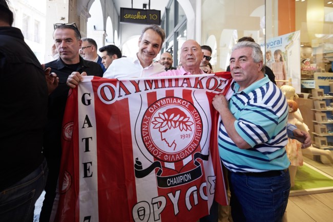 Conference League: Ο Κυριάκος Μητσοτάκης χαμογελαστός κρατάει τη σημαία του Ολυμπιακού
