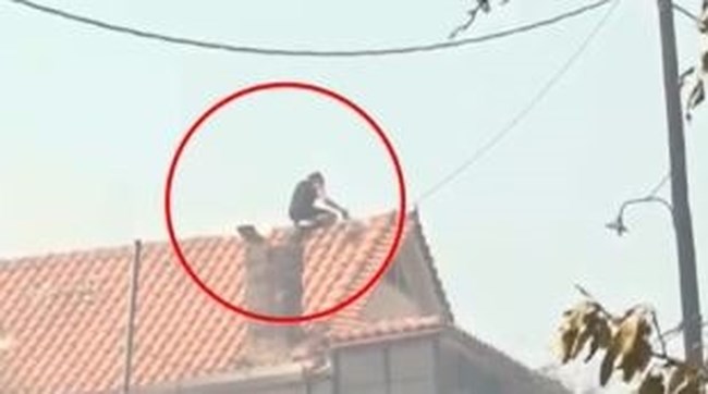 Μάχη με τις φλόγες για να μην καούν οι περιουσίες: Ανέβηκε σε σκεπή σπιτιού φίλου του στη Φυλή για να το σώσει