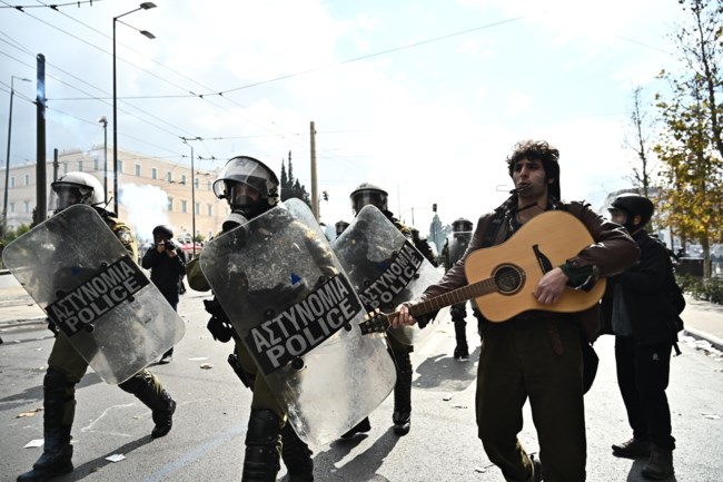 Διαδηλωτής με την κιθάρα του εν μέσω επεισοδίων