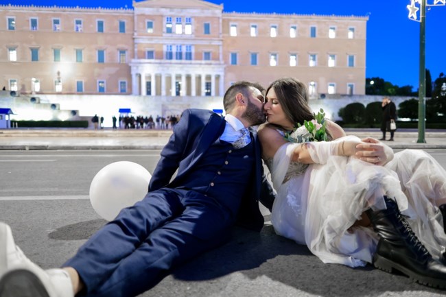 Νεόνυμφοι φωτογραφήθηκαν στο Σύνταγμα: Με φόντο το χριστουγεννιάτικο δέντρο, τη Βουλή και την... πορεία των ένστολων