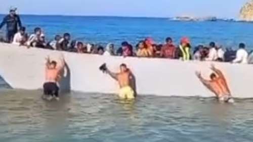 Γαύδος: Λουόμενοι σπρώχνουν με τα χέρια τους βάρκα με μετανάστες που φτάνει στην παραλία [βίντεο]