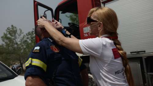 Πυρκαγιές στην Αττική: Η στιγμή που διασώστρια του Ερυθρού Σταυρού προσφέρει πρώτες βοήθειες σε πυροσβέστη [εικόνες]