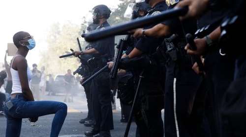 ΗΠΑ: Μαύρη διαδηλώτρια γονατίζει μπροστά σε &quot;τείχος&quot; αστυνομικών - Η εικόνα που έγινε viral