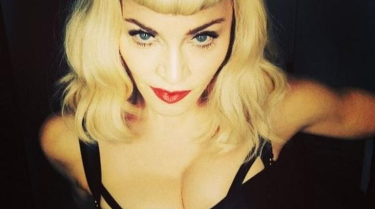 Η Madonna ξαπλωμένη και τρεις να την... «δένουν»