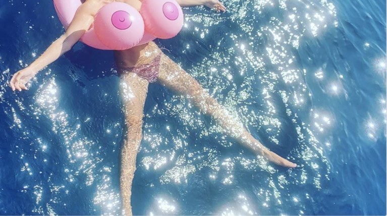 Μια νεόνυμφη ποζάρει topless μέσα στην πισίνα