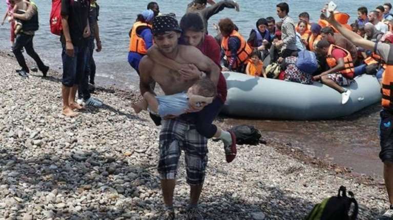 Πρόσφυγας κουβαλάει την τυφλή γυναίκα του και το μωρό τους