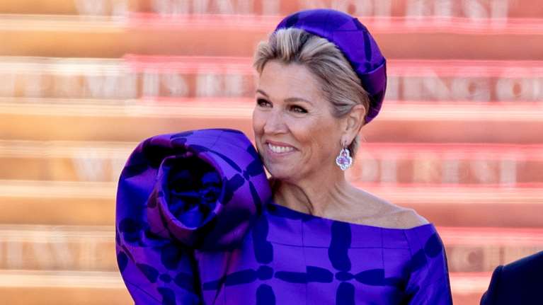 Υπερβολική όπως πάντα: Η βασίλισσα Μάξιμα με φόρεμα με τεράστιο λουλούδι που έκρυψε το κεφάλι της