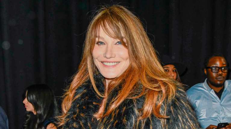 H Κάρλα Μπρούνι με over the knee μπότες και τεράστια γούνα στο Παρίσι - Προκλητική και chic στα 56 της