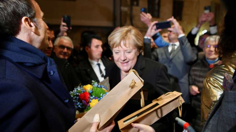 Ο συγκινητικός αποχαιρετισμός του Μακρόν στην Ανγκελα Μέρκελ με κρασιά και λουλούδια [εικόνες]