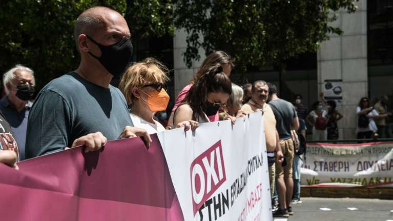 Με tweet στα αγγλικά και μωβ πανό ο Βαρουφάκης διαδηλώνει: Οχι στην εργασιακή ζούγκλα
