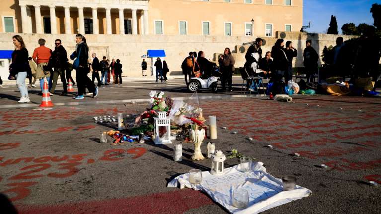 Σύνταγμα: Λουλούδια, κεριά και αντικείμενα πάνω στα ονόματα των 57 θυμάτων των Τεμπών [εικόνες]