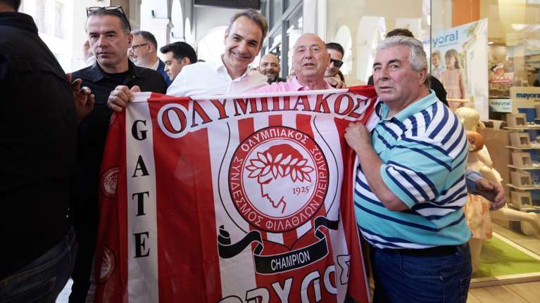 Conference League: Ο Κυριάκος Μητσοτάκης χαμογελαστός κρατάει τη σημαία του Ολυμπιακού