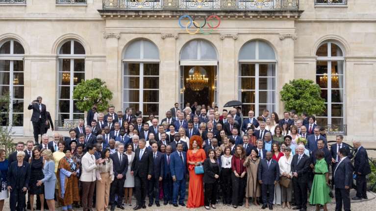 Παρίσι 2024: Ποια είναι η εντυπωσιακή κυρία με τα κόκκινα και την άφρο κόμμωση - Το Welcome friends! του Μακρόν